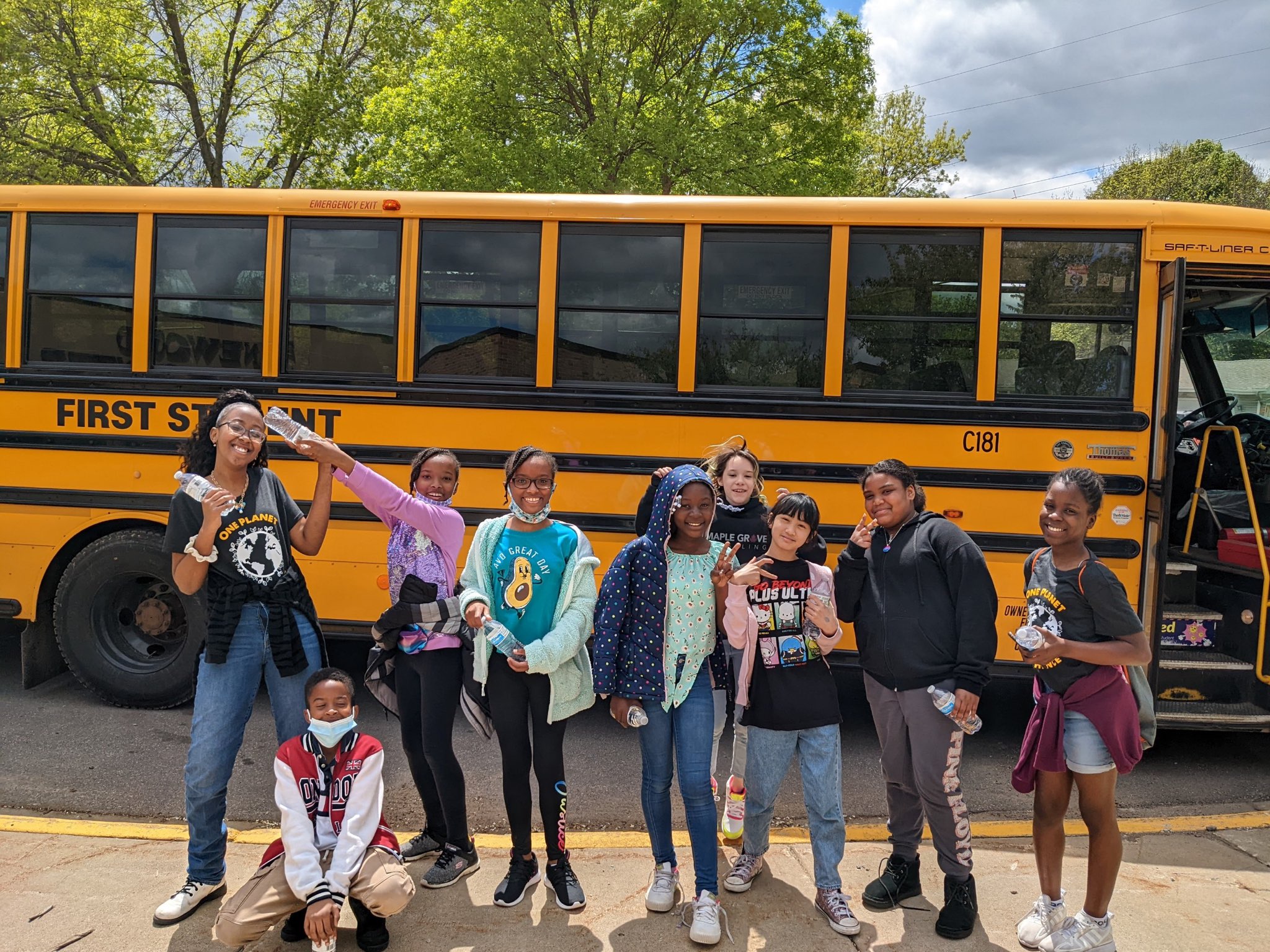 Code Savvy students gathered in front of a school bus