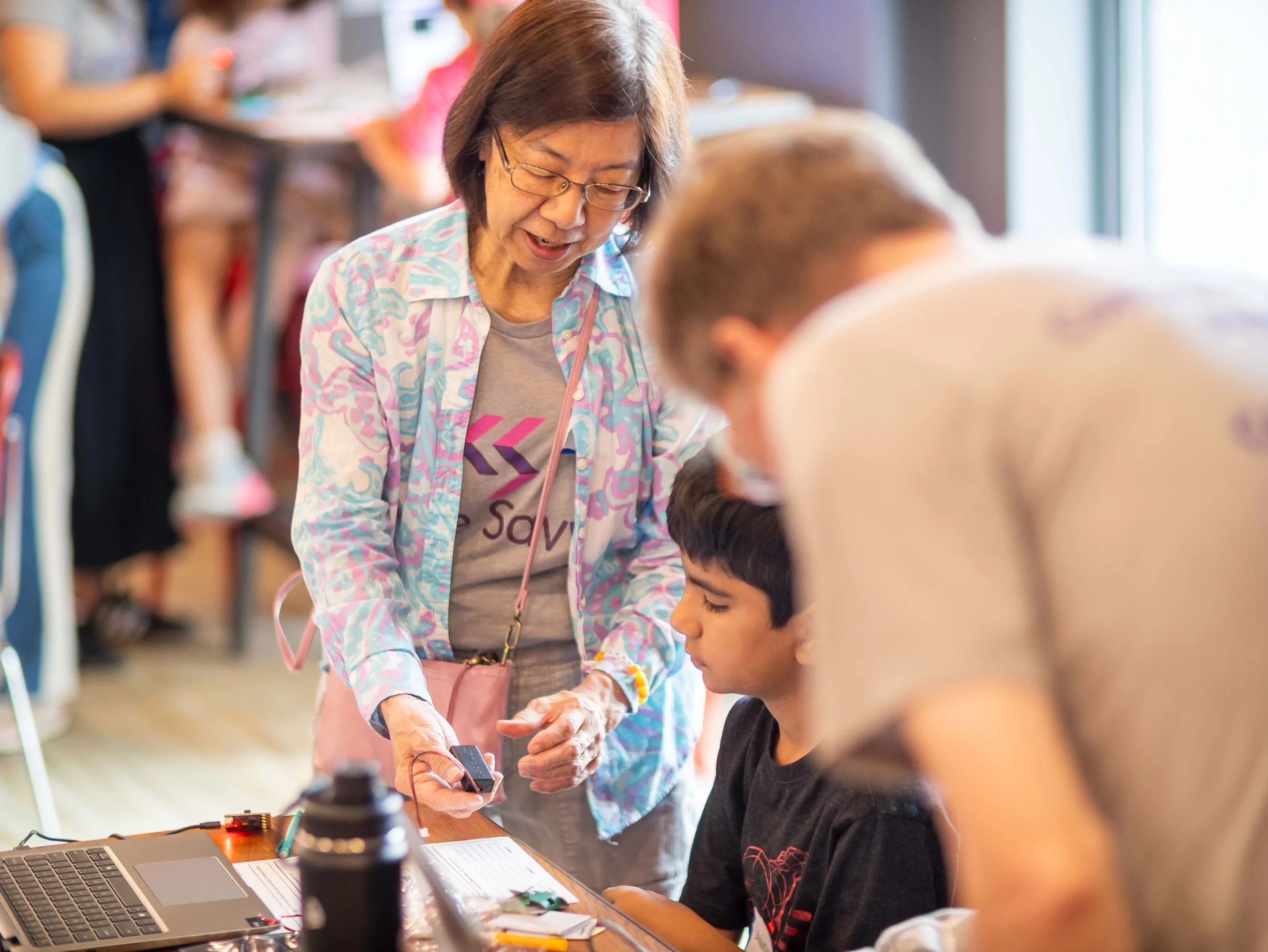 Volunteer helping students during a Code Savvy hackathon