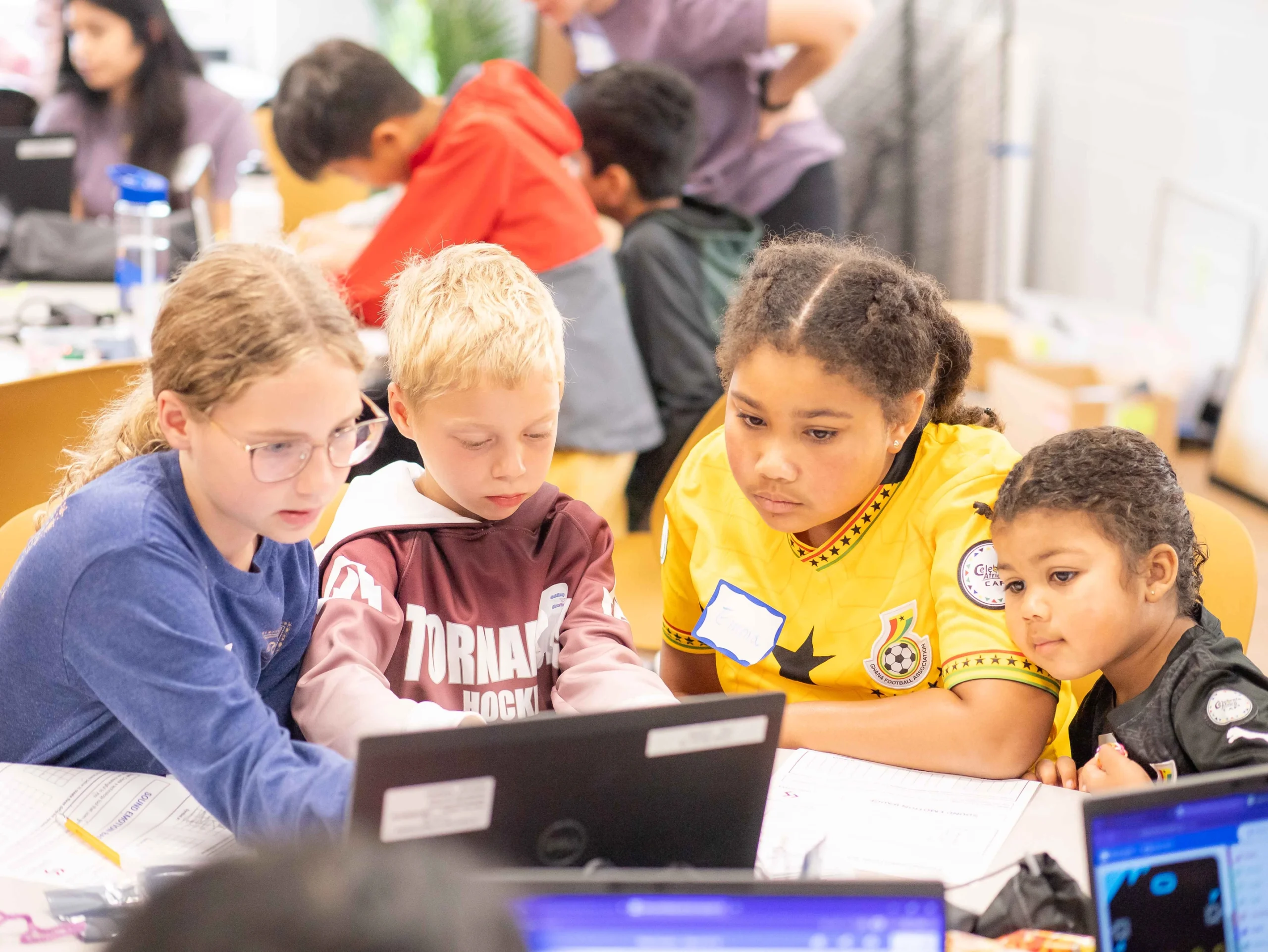 Four students collaborating on a project during a Code Savvy program