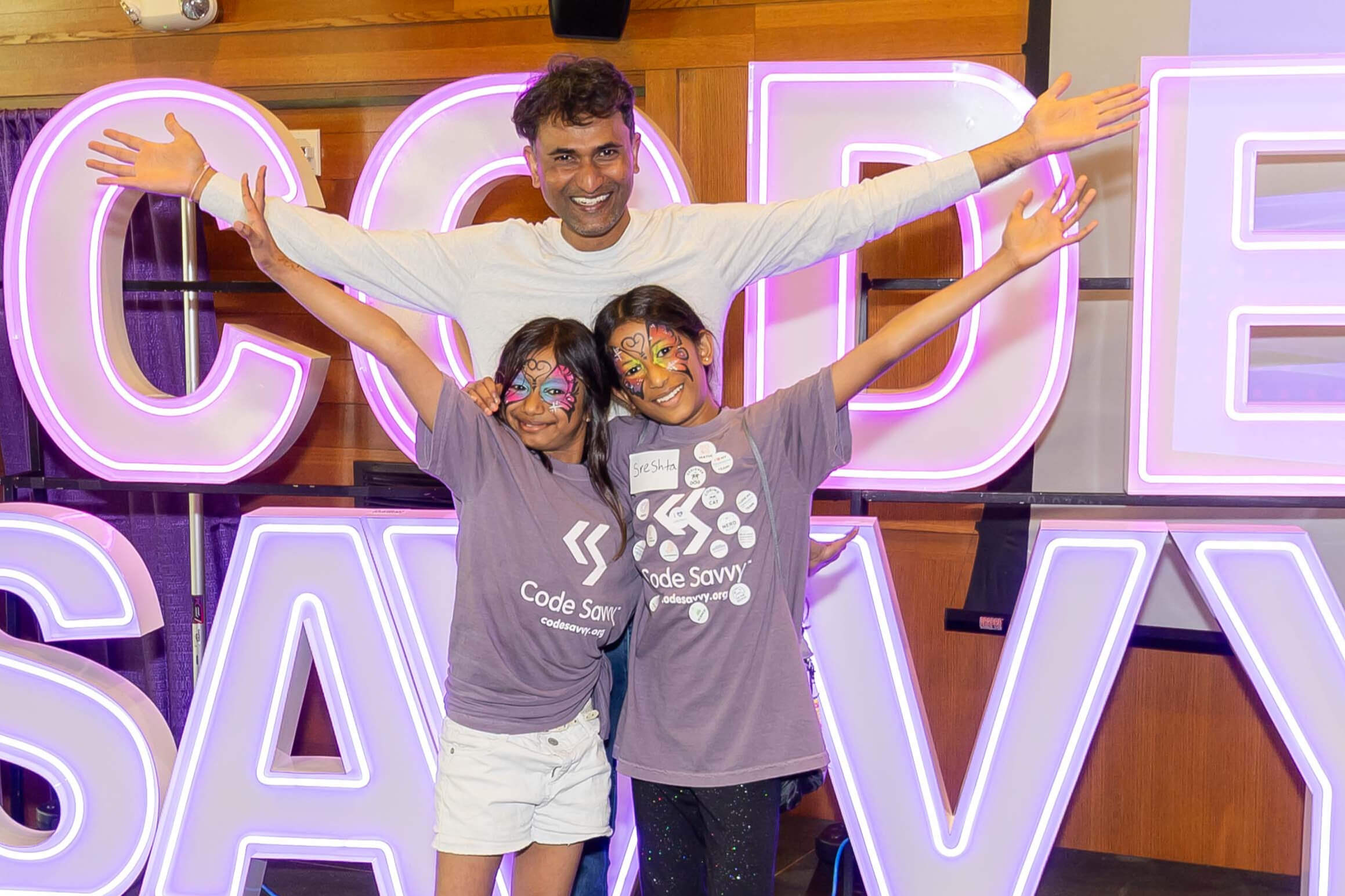 Two Technovation Girls Minnesota participants celebrating with a parent.