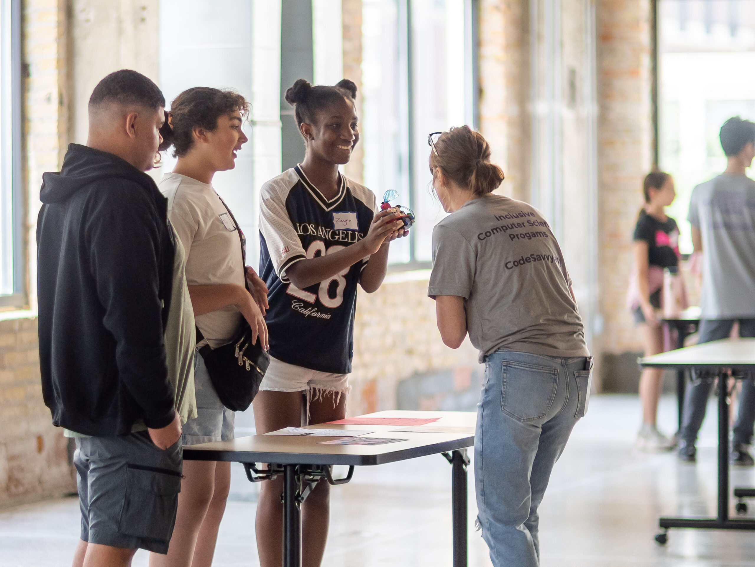 Students presenting a project to a judge at a Code Savvy hackathon